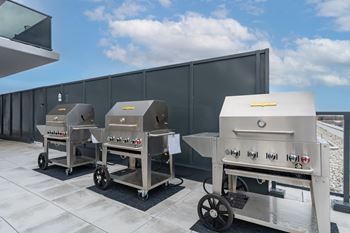 Three industrial ovens are lined up on a patio